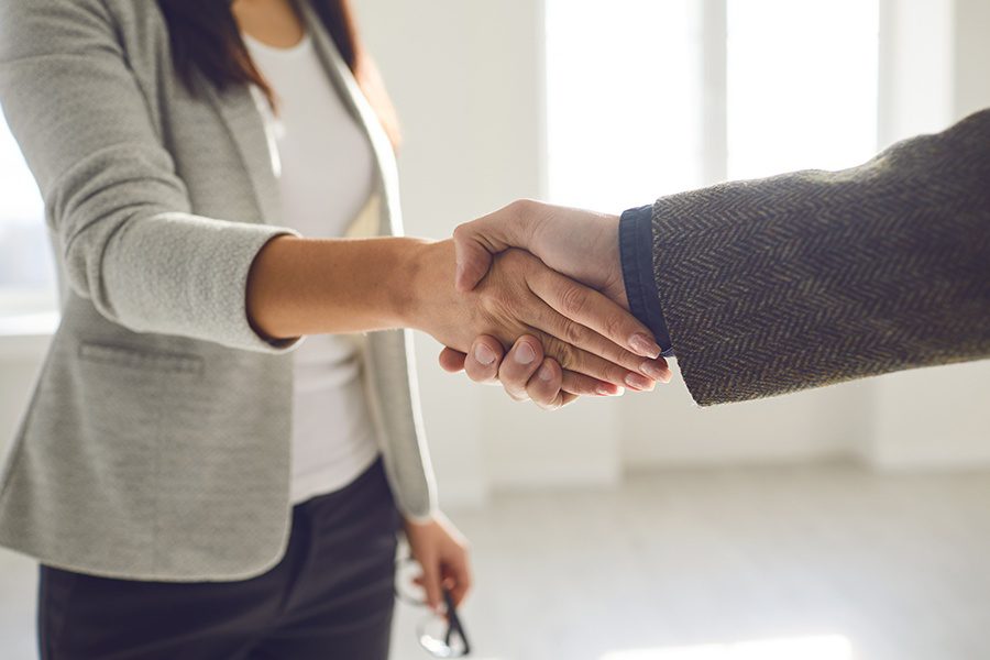 About Our Agency - Courtney Pierce Shaking Hands of Business Associate in the Her Office